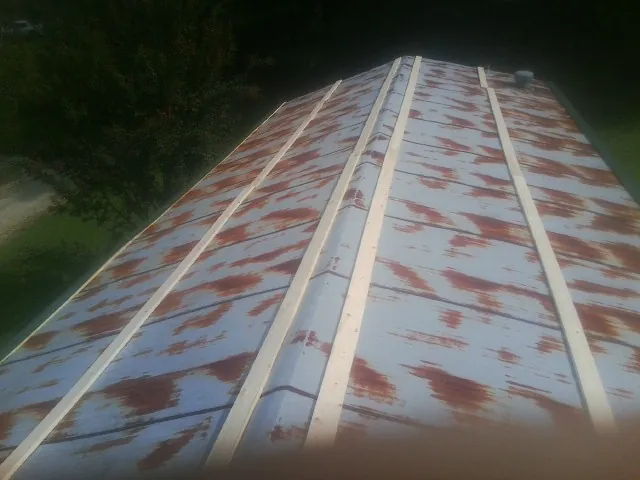 Rusted metal roof panels with new wood purlins before replacement — Storm Damage Roof Repair in Pfeifer by Roofing Brothers