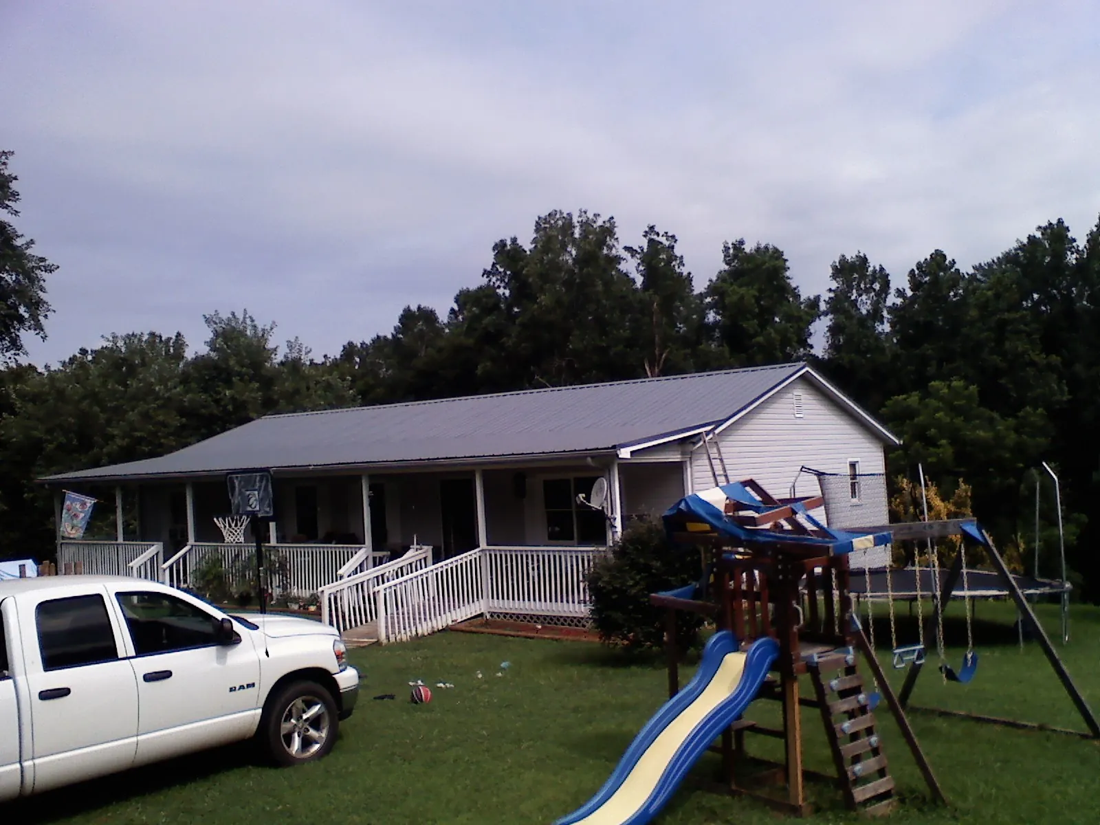 Dark metal roof on a country home with a full length front porch in Pfeifer