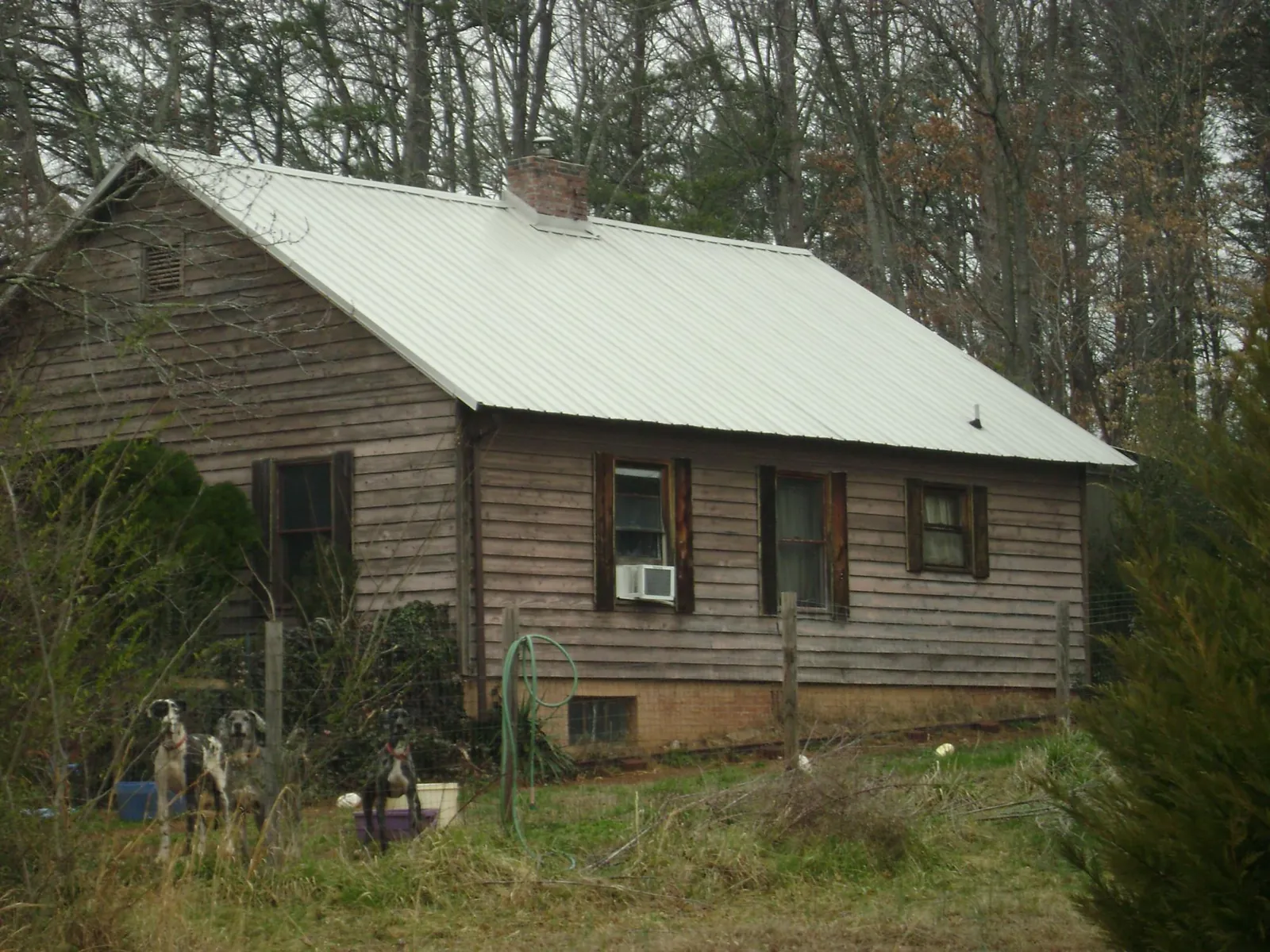 White metal roof on an old wood sided farmhouse, from a Metal Roof Installation job in Pfeifer